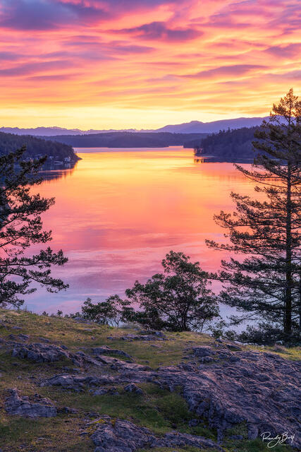 sunrise at Deception Pass Washington with colorful clouds and reflections in the water.