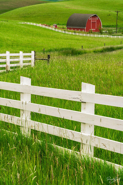 red barn with a fence in a z pattern.