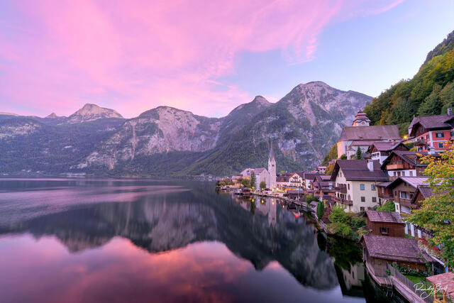 Sunset at Hallstat, Austria with colorful clouds above the mountains reflecting in Hallstatt Lake.