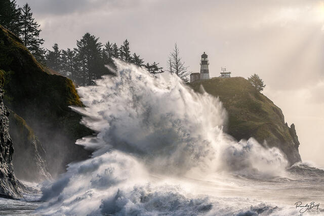 Crashing waves at Cape Disapppointment State Park with the lighthouse.