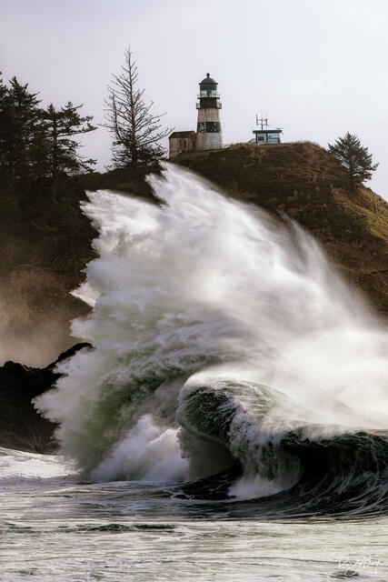 Crashing waves at Cape Disapppointment State Park with the lighthouse.