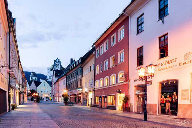 sunrise in fussen, Germany with the cobbled streets and light posts casting warm light on the scene