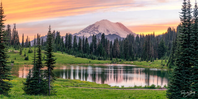 Sunset at Tipsoo Lake with Mount Rainier reflecting in the calm water.