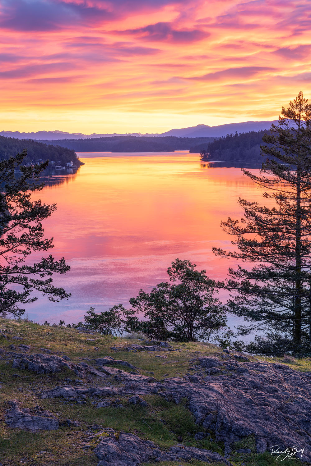 sunrise at Deception Pass Washington with colorful clouds and reflections in the water.